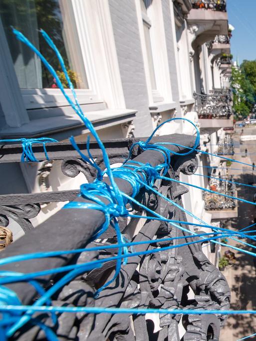 Ein Netz aus Pressengarn ist in Hamburg zwischen Häusern im Grindelviertel gespannt. Mit der Aktion des Kieler Künstlers M. Wolf wollen die Bewohner des Grindelviertels ihre Verbundenheit symbolisieren.