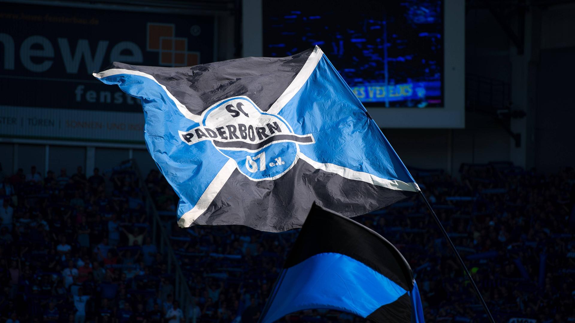 Eine große blau-schwarze Schwenkfahne mit dem Logo des SC Paderborn.