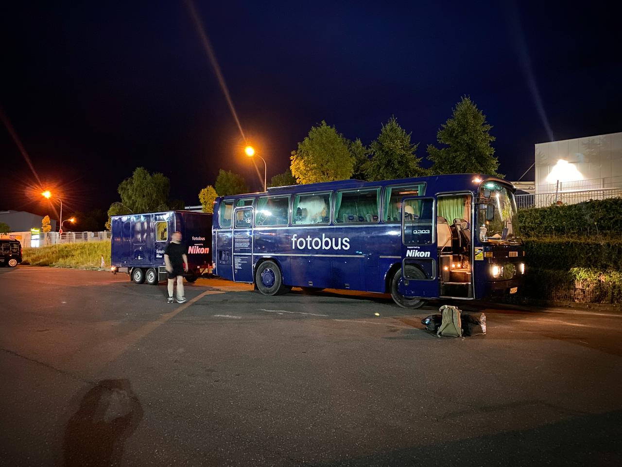 Der Fotobus, ein Mercedes-Reisebus in Dunkelblau steht mit Anhänger auf einem Parkplatz Der Fotobus, ein Mercedes-Reisebus in Dunkelblau steht mit Anhänger auf einem Parkplatz