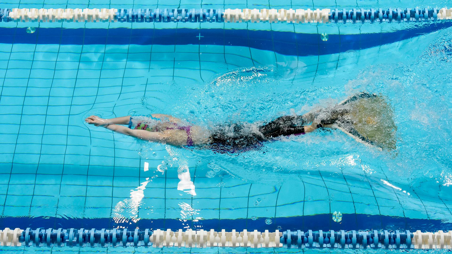 Finswimming Wettbewerb: Eine junge Schwimmerin mit einer Monoflosse im Wasser.
