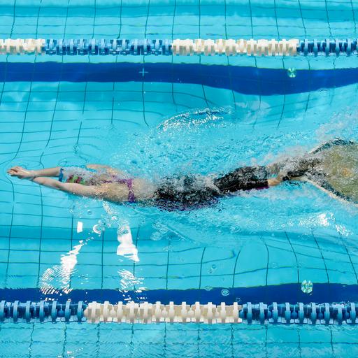 Finswimming Wettbewerb: Eine junge Schwimmerin mit einer Monoflosse im Wasser.