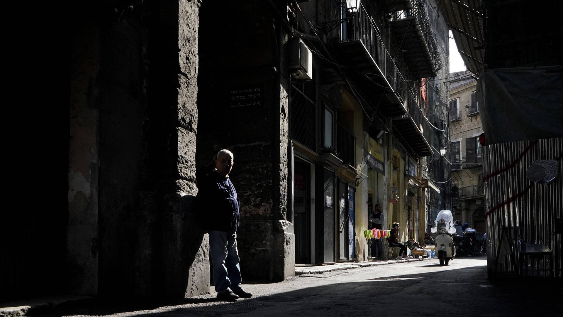 Ein Mann im Schatten auf einer Gasse in Palermos 