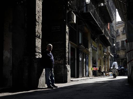 Ein Mann im Schatten auf einer Gasse in Palermos 