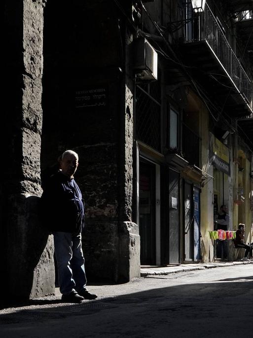 Ein Mann im Schatten auf einer Gasse in Palermos 