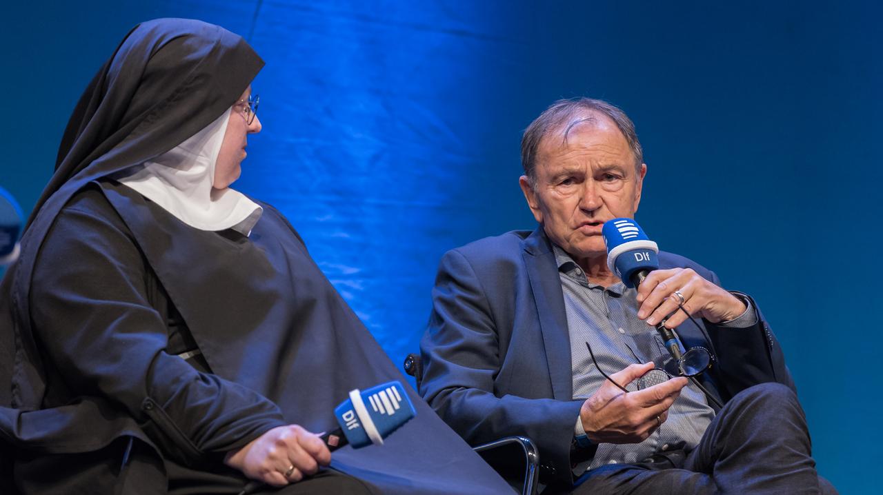 Das Foto zeigt Schwester Emmanuela Kohlhaas und Ewald Lienen beim "Forum für Journalismuskritik.