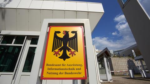 Die Außenfassade eines Gebäudes des Bundesamts für Ausrüstung, Informationstechnik und Nutzung der Bundeswehr, im Vordergrund befindet sich ein Schild mit dem Namen der Behörde.