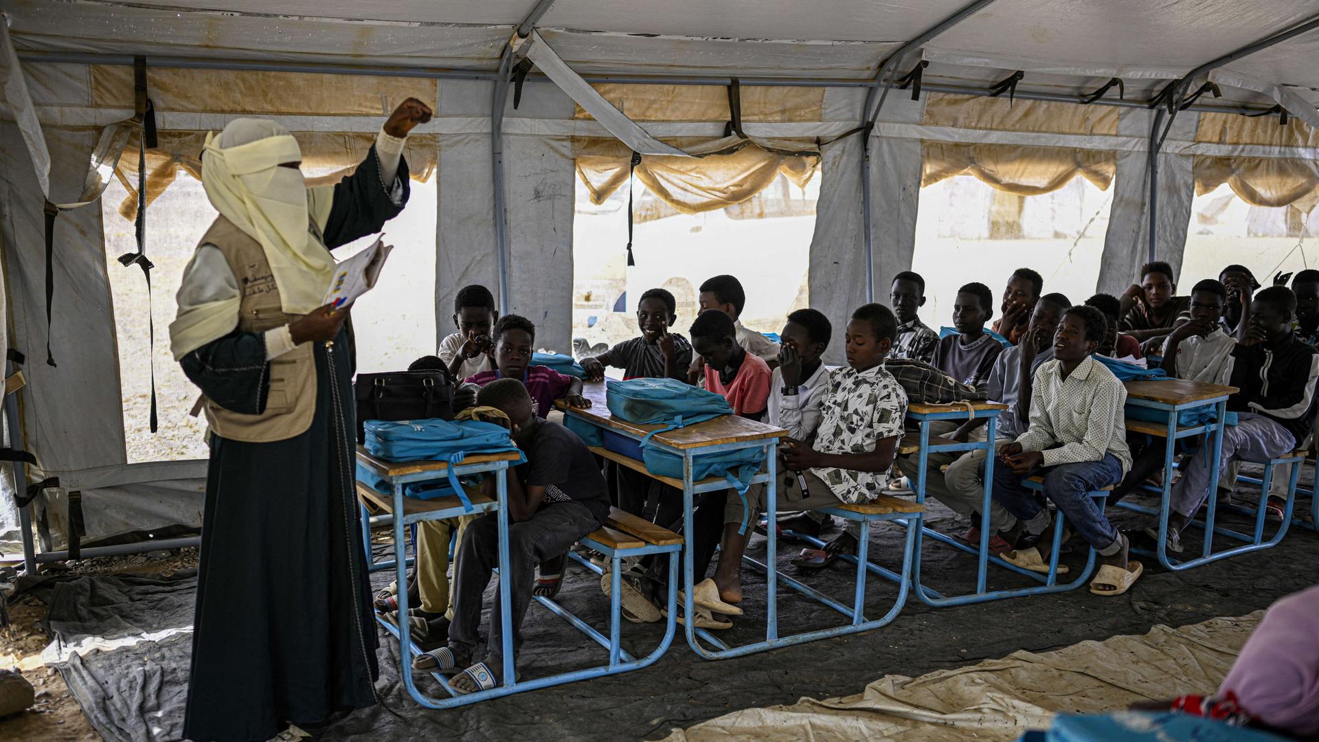 Aus dem Land Sudan vertriebene Kinder. Sie werden in einem Zelt von einem Lehrer unterrichtet. Aus dem Land Sudan vertriebene Kinder. Sie werden in einem Zelt von einem Lehrer unterrichtet.
