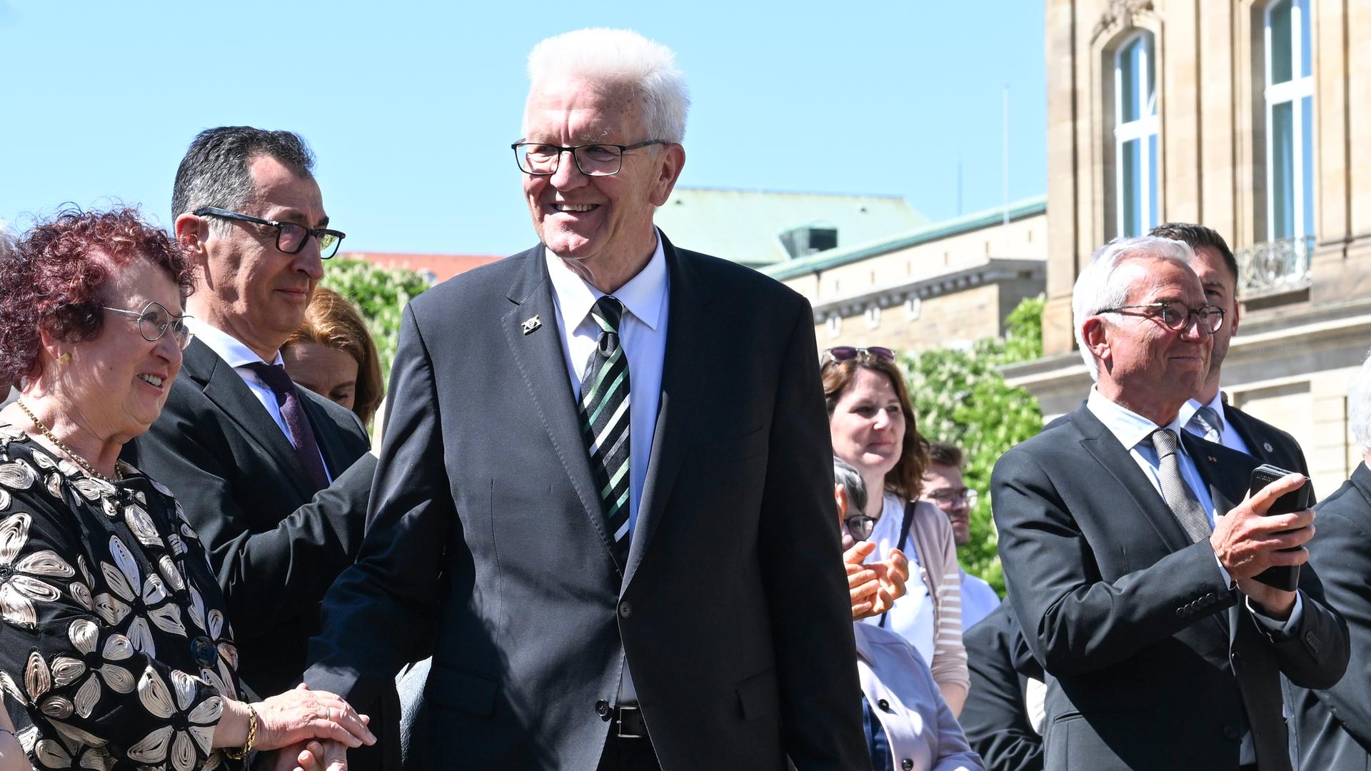 Kretschmann steht beim Festakt zu seiner Verabschiedung neben seiner Frau und seinem designiertern Nachfolger Özdemir.