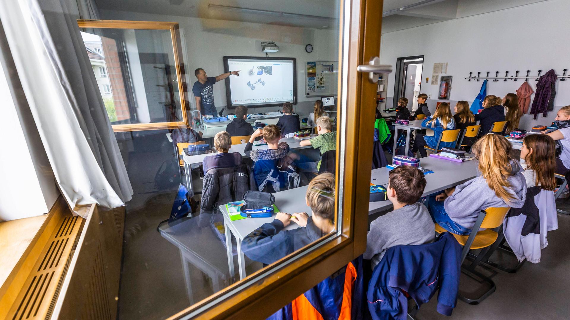 Physik-Unterricht bei geöffneten Fenstern in einer Klasse an einem Gymnasium.