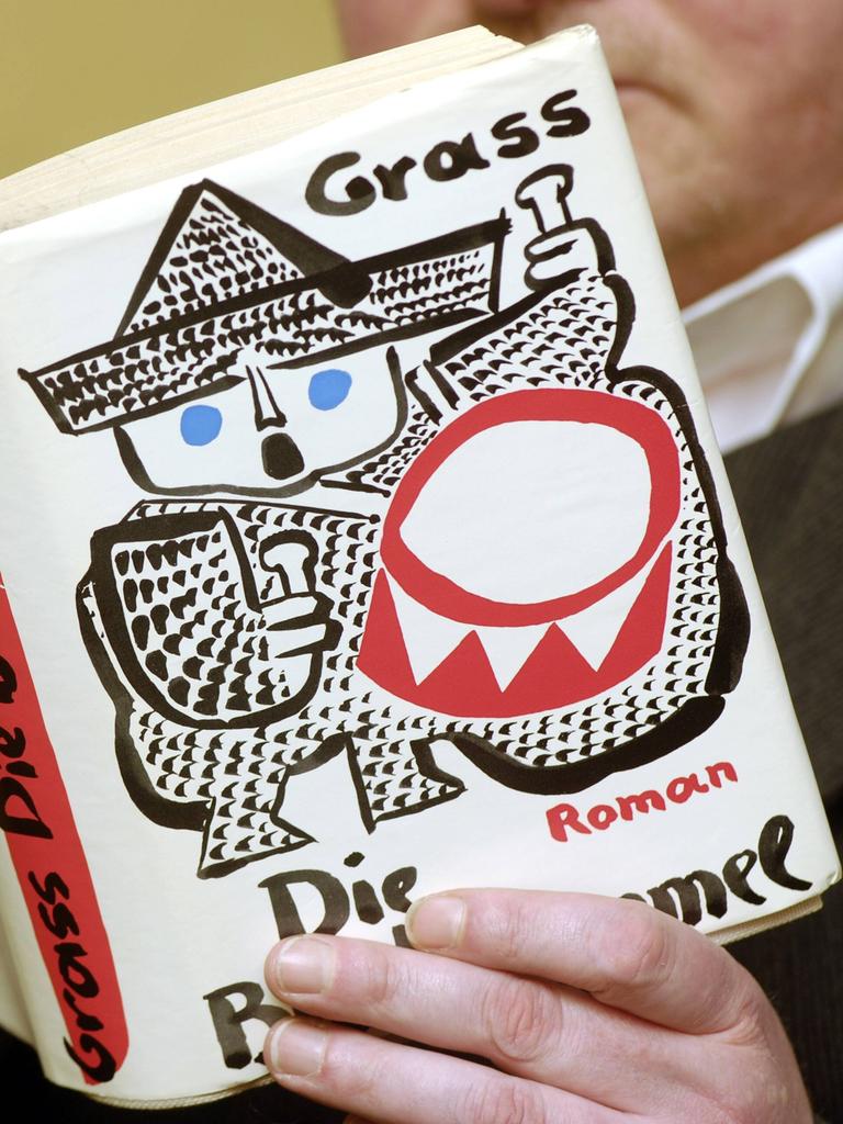 Ein Mann liest das Buch "Die Blechtrommel" und hält es aufgeklappt vor sich.