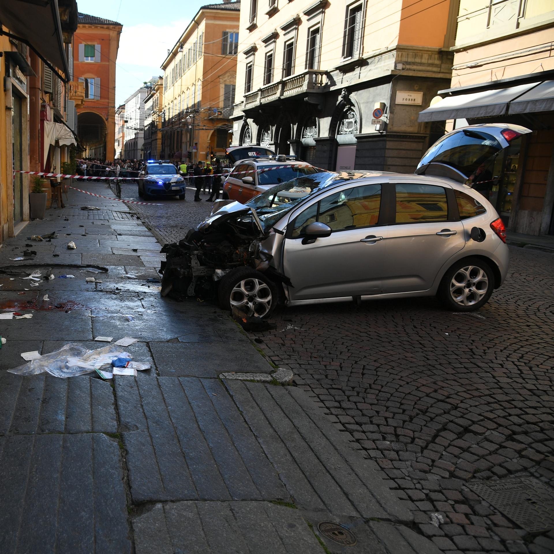 Das Bild zeigt einen zerstörten Pkw in der Stadt Modena in Italien. Ein Mann hat dem Auto mehrere Passanten teils schwer verletzt. 