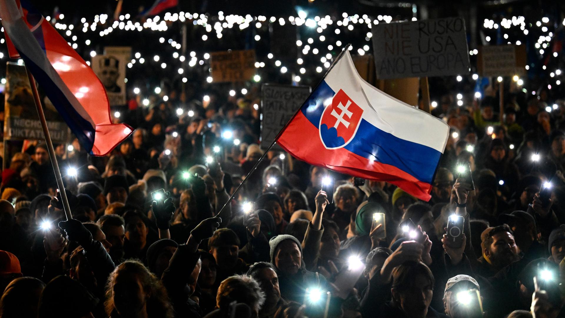 Zahlreiche Menschen halten ihre Handys hoch während eines Protests gegen die Politik des linksnationalen Ministerpräsidenten Fico.