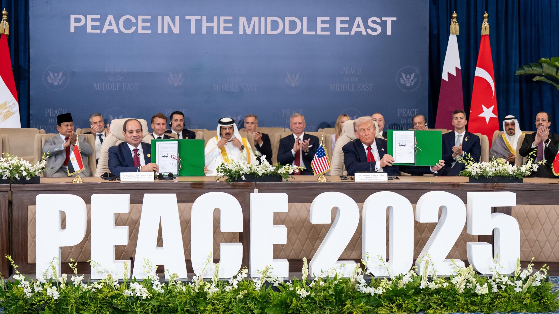 Abdell-Fattah al-Sisi (l), Präsident von Ägypten, und US-Präsident Donald Trump (r), halten eine Erklärung zum Gaza-Krieg hoch. Davor der Schriftzug "Peace 2025"