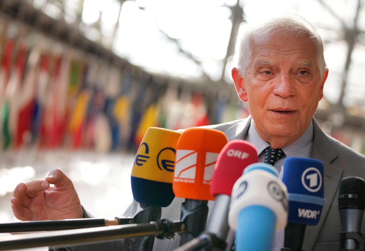 Borrell steht vor Mikrofonen. Im Hintergrund verschwommen die Fahnen der EU-Mitglieder.