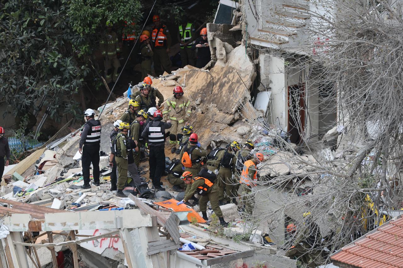Rettungskräfte stehen auf den Trümmern eines Hauses. Rettungskräfte stehen auf den Trümmern eines Hauses.