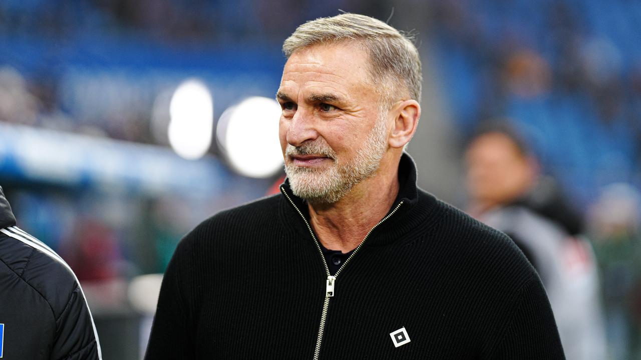 Stefan Kuntz steht am Spielfeldrand. Er trägt einen schwarzen Pullover mit dem Logo des HSV darauf.