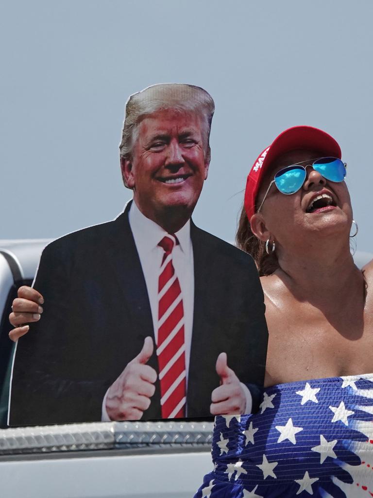 Eine Frau hält einen Pappaufsteller im Arm, auf dem Donald Trump abgebildet ist. 