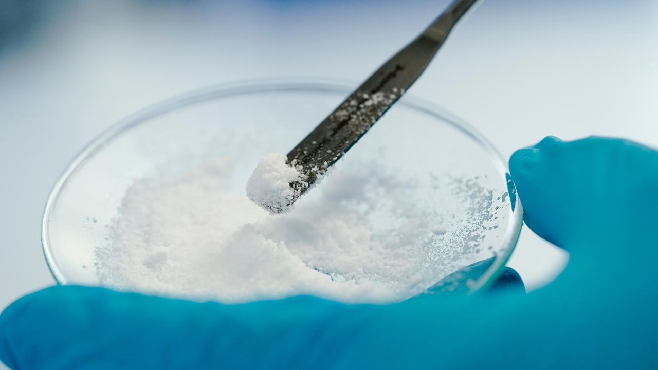 Eine Mitarbeiterin hält in einem Labor der Vulcan Energie eine Glasschale mit Lithiumchlorid in den Händen.