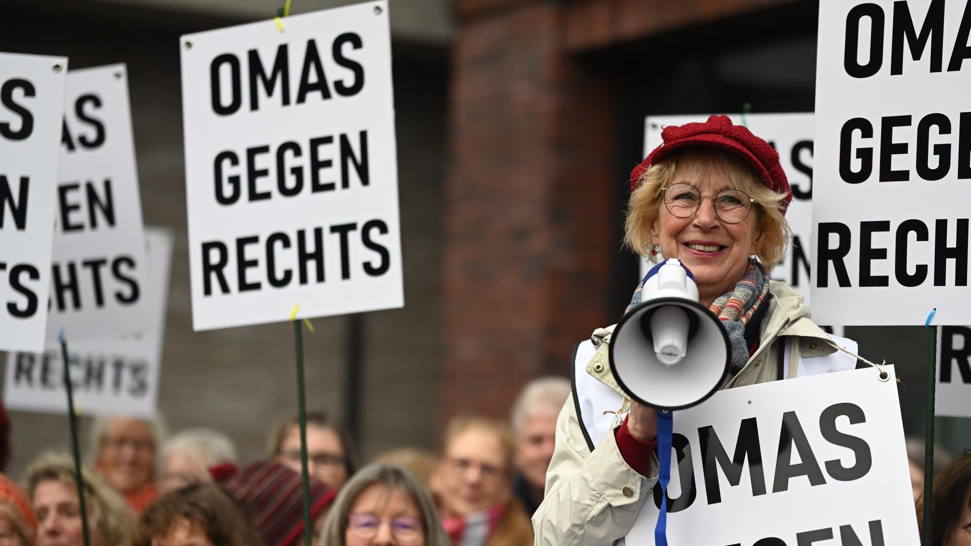 Teilnehmerinnen einer Demonstration von "Omas gegen Rechts" mit mehreren Transparenten. 