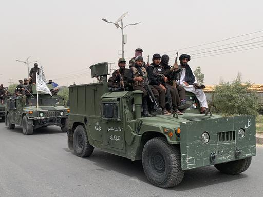 Bewaffnete Taliban fahren mit einem Konvoi aus vormalig amerikanischen Armeefahryeugen durch Kandahar.