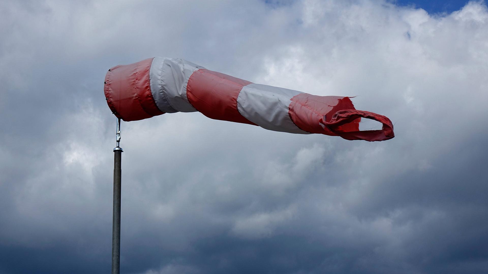 Vor Wolken befindet sich ein aufgeblähter Windsack.
