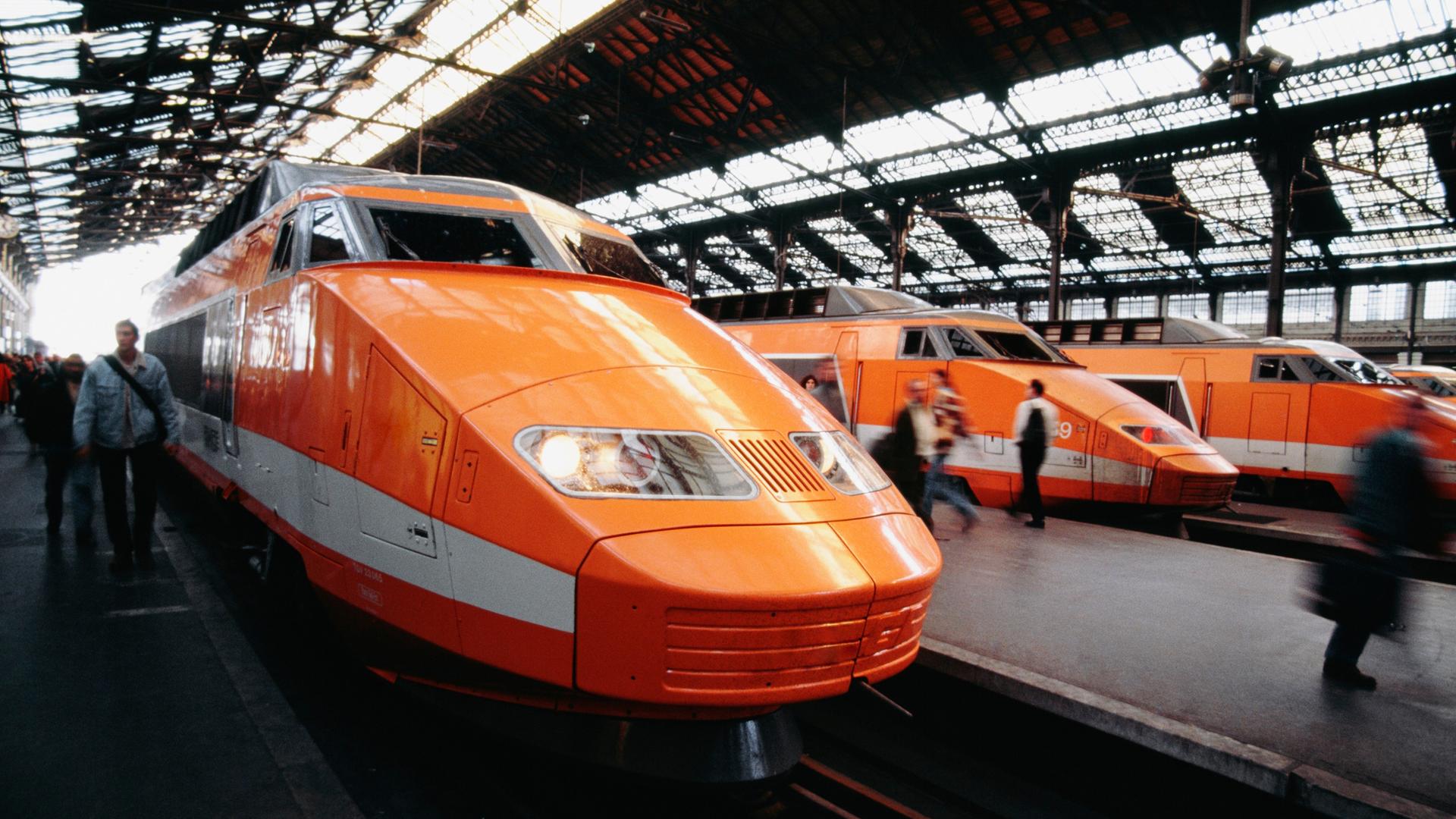 TGV Züge in orange stehen in einem Bahnhof.