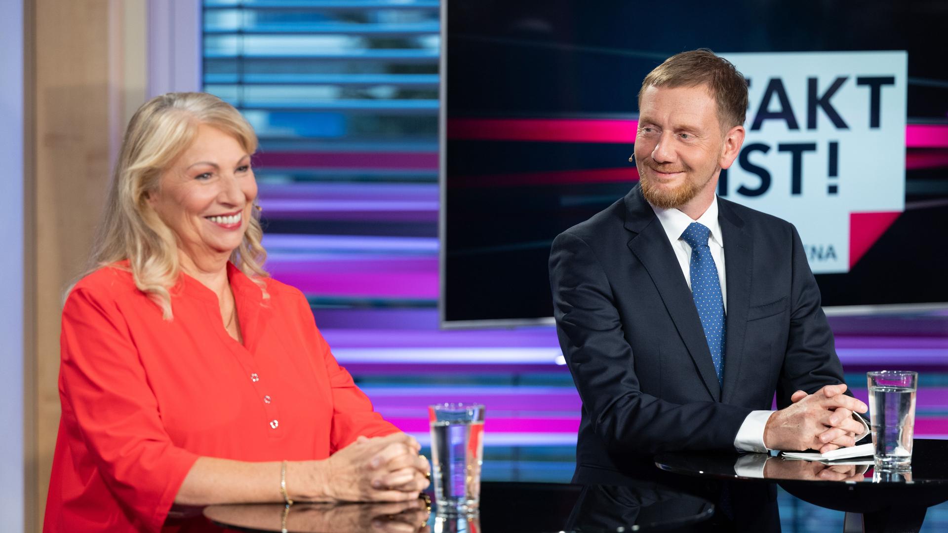 Petra Köpping (SPD), Sozialministerin von Sachsen, und Michael Kretschmer (CDU), Ministerpräsident von Sachsen, stehen vor Beginn der TV-Wahlarena des MDR in einem Saal der Handwerkskammer Dresden nebeneinander.