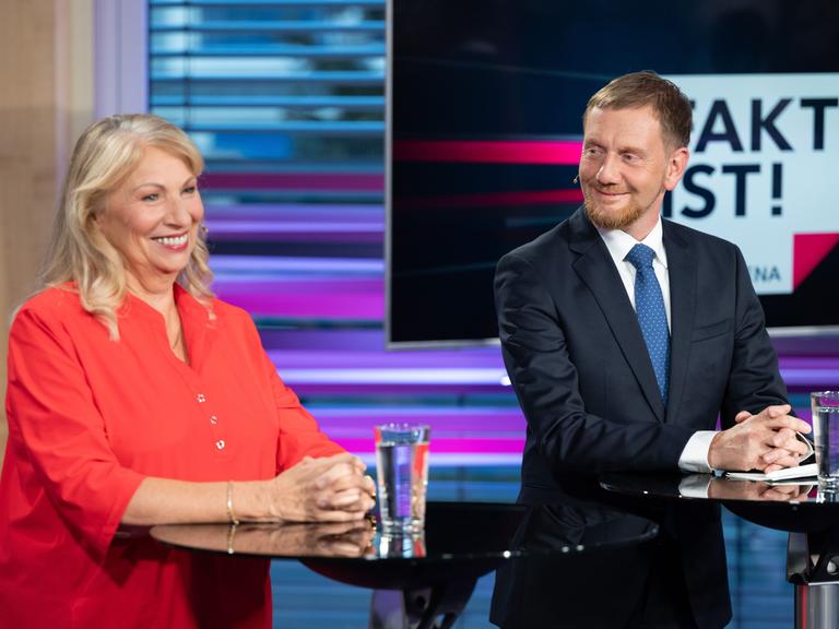 Petra Köpping (SPD), Sozialministerin von Sachsen, und Michael Kretschmer (CDU), Ministerpräsident von Sachsen, stehen vor Beginn der TV-Wahlarena des MDR in einem Saal der Handwerkskammer Dresden nebeneinander.