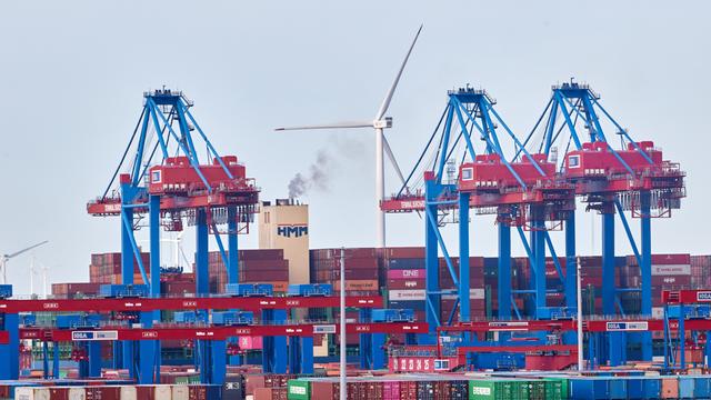 Kräne, Container und ein Windrad sind im Hamburger Hafen zu sehen.