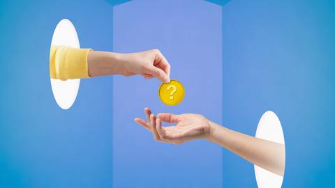 Die Hand einer jungen Frau hält eine Münze mit einem Fragezeichen über der Hand einer anderen Frau, beide kommen durch Löcher im blauen Raum.