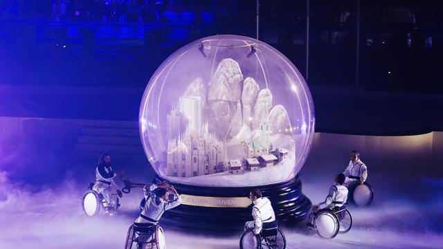 Bei der Abschluss-Feier sind Roll-Stuhl-Fahrer um eine riesige Schnee-Kugel gefahren.