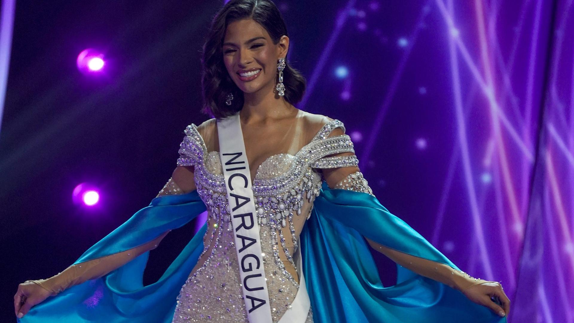 Sheynnis Palacios in einem weißen Kleid mit blauem Umhang, auf ihrer Schärpe steht der Schriftzug "Nicaragua".