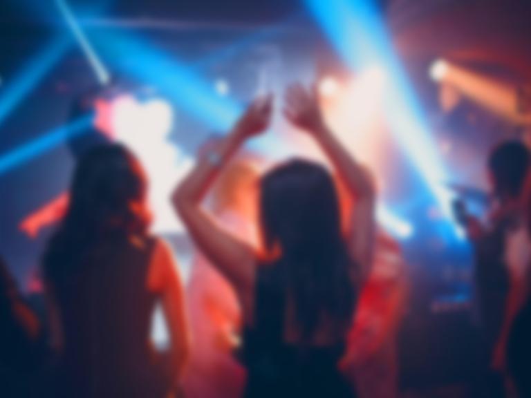 Verschwommene Umrisse zweier Frauen, die in einem Club tanzen
