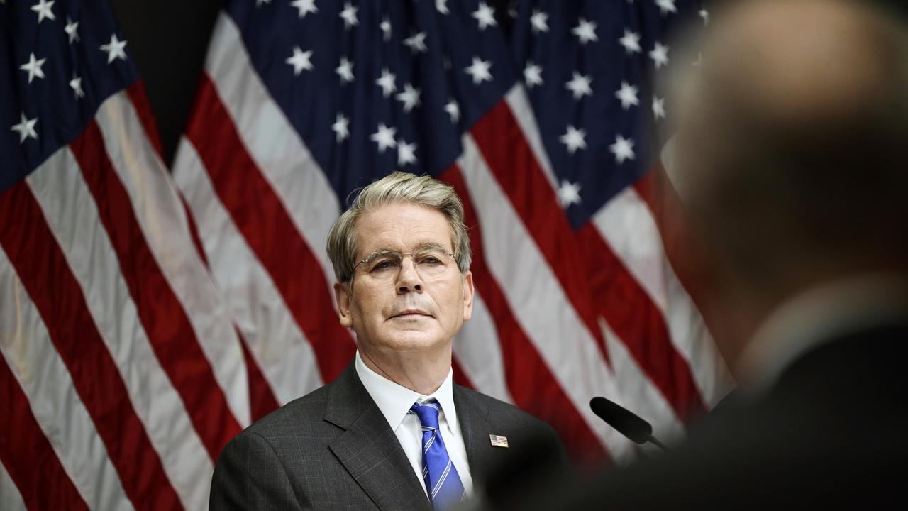 US-Finanzminister Scott Bessent steht vor mehreren US-Flaggen. 