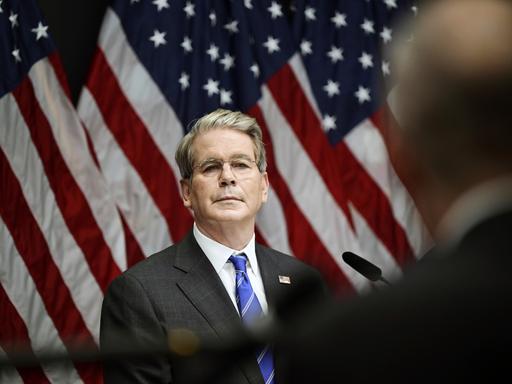 US-Finanzminister Scott Bessent steht vor mehreren US-Flaggen. 