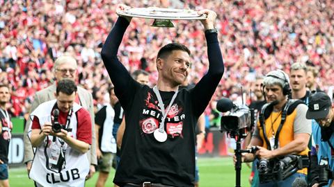 Xabi Alonso, Trainer von Bayer 04 Leverkusen, streckt die Meisterschale nach oben.