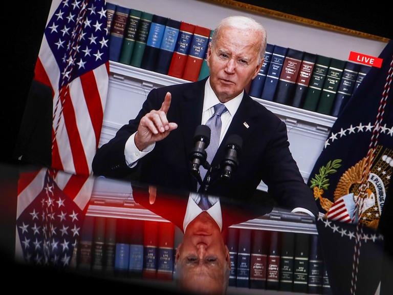US-Präsident Joe Biden hält eine Rede. Im Hintergrund ist eine Bücherregal zu sehen.