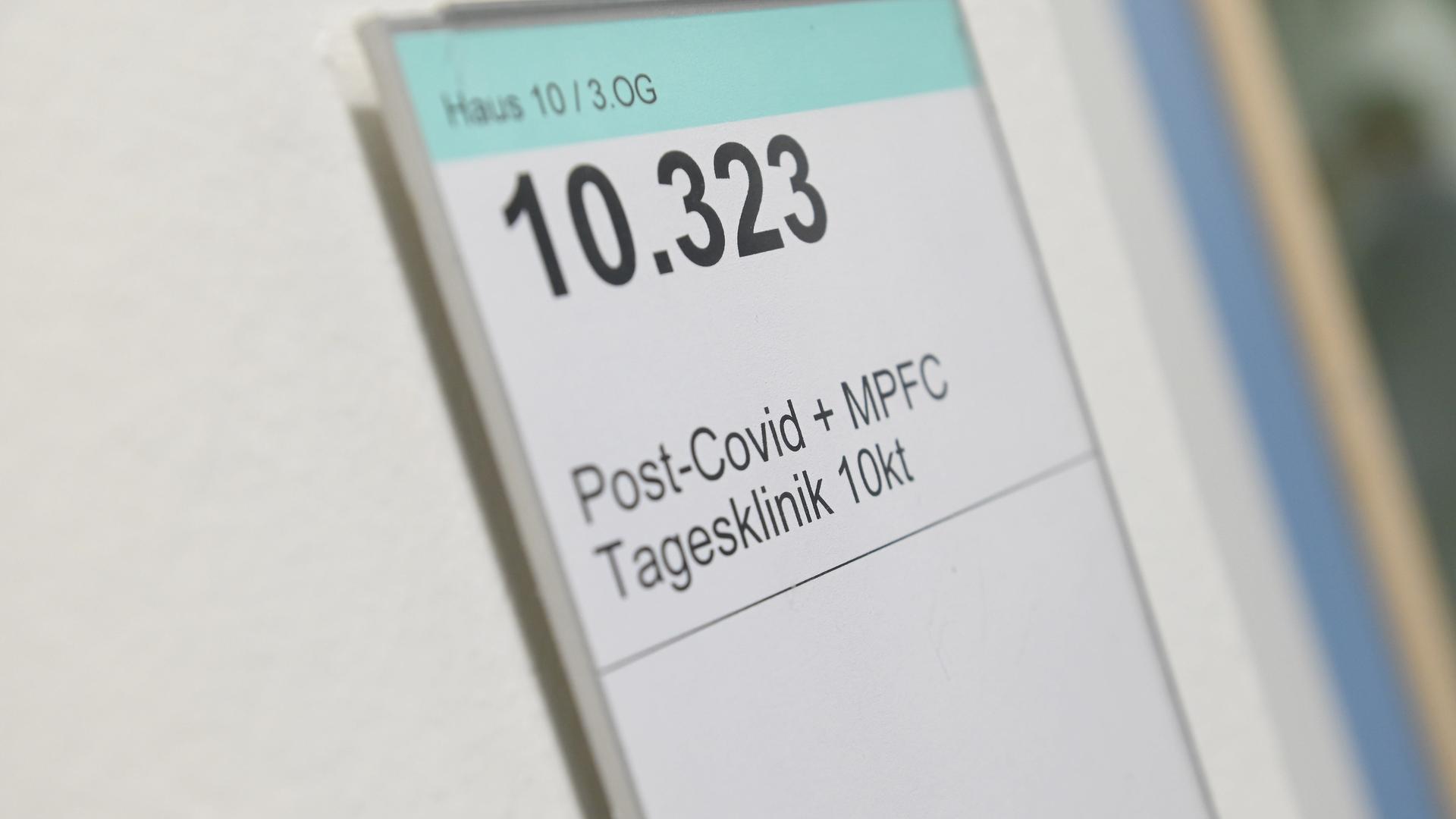 Auf einem Schild an einem Krankenhauszimmer steht Haus 10 / 3 OG, groß 10.323, Post-Covid + MFPC-Tagesklinik