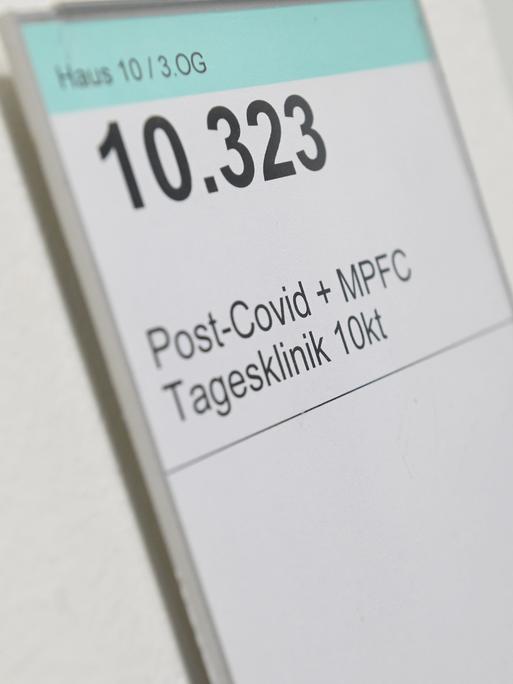 Auf einem Schild an einem Krankenhauszimmer steht Haus 10 / 3 OG, groß 10.323, Post-Covid + MFPC-Tagesklinik