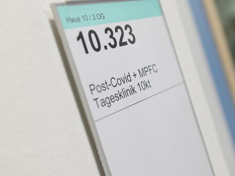 Auf einem Schild an einem Krankenhauszimmer steht Haus 10 / 3 OG, groß 10.323, Post-Covid + MFPC-Tagesklinik