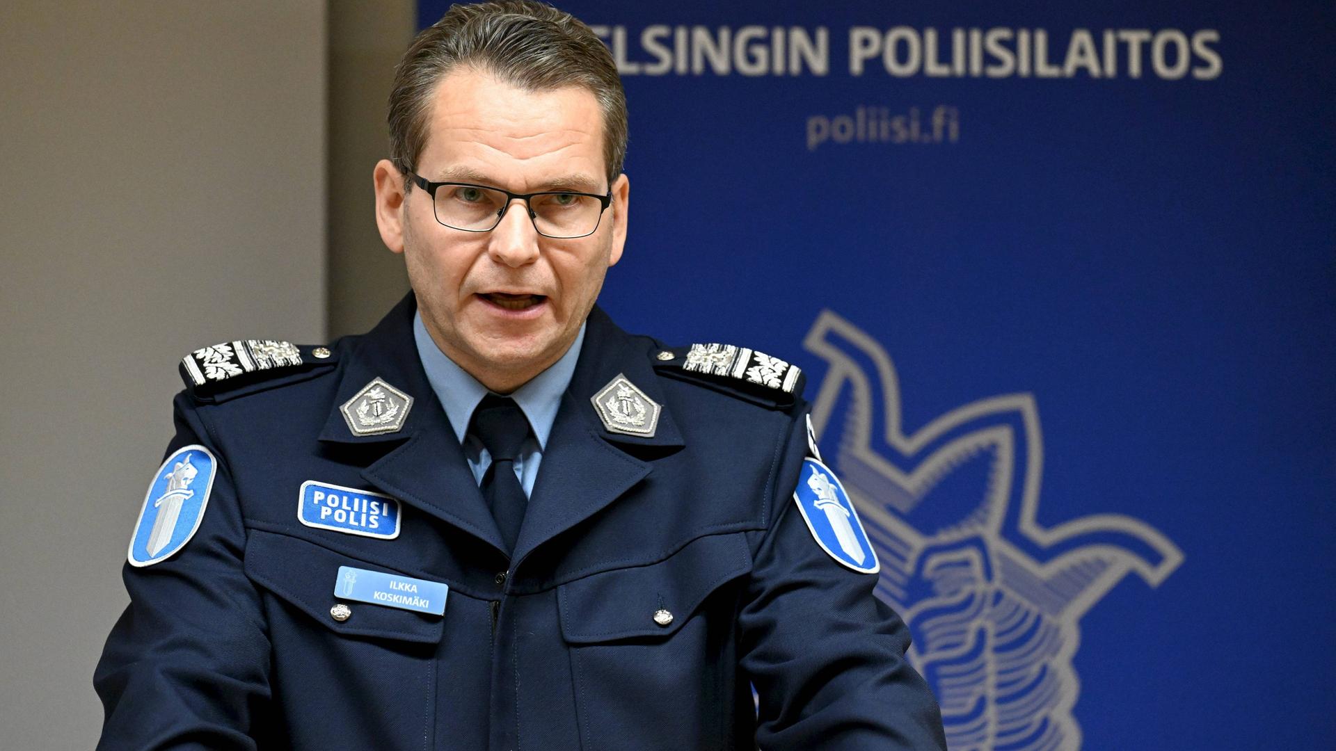 Ein finnischer Polizist sitzt während einer Pressekonferenz vor einem Mikrofon. Ein finnischer Polizist sitzt während einer Pressekonferenz vor einem Mikrofon.