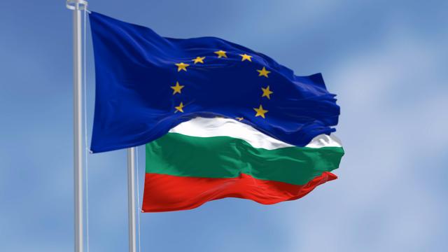 Nationalflagge Bulgariens und EU-Flagge wehen im Wind.