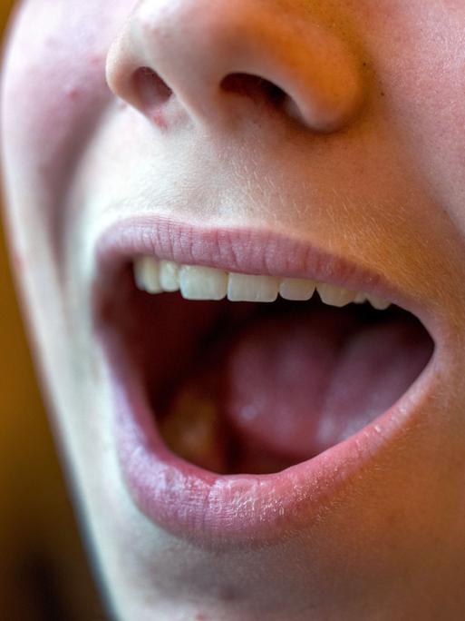 Ein geöffneter singender Mund in Nahaufnahme mit Nase, aber ohne Augenpartie. Ein geöffneter singender Mund in Nahaufnahme mit Nase, aber ohne Augenpartie.
