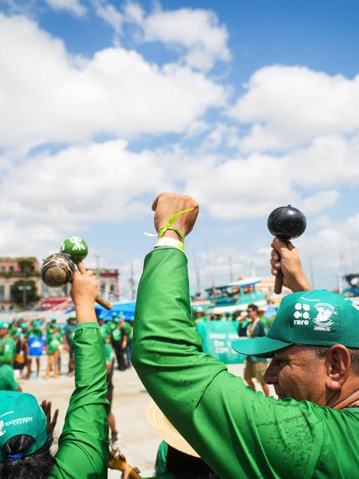 Protestierende in überwiegend grüner Kleidung vor Gebäuden auf der Straße. Manche recken ihre Fäuste in die Höhe. Protestierende in überwiegend grüner Kleidung vor Gebäuden auf der Straße. Manche recken ihre Fäuste in die Höhe.