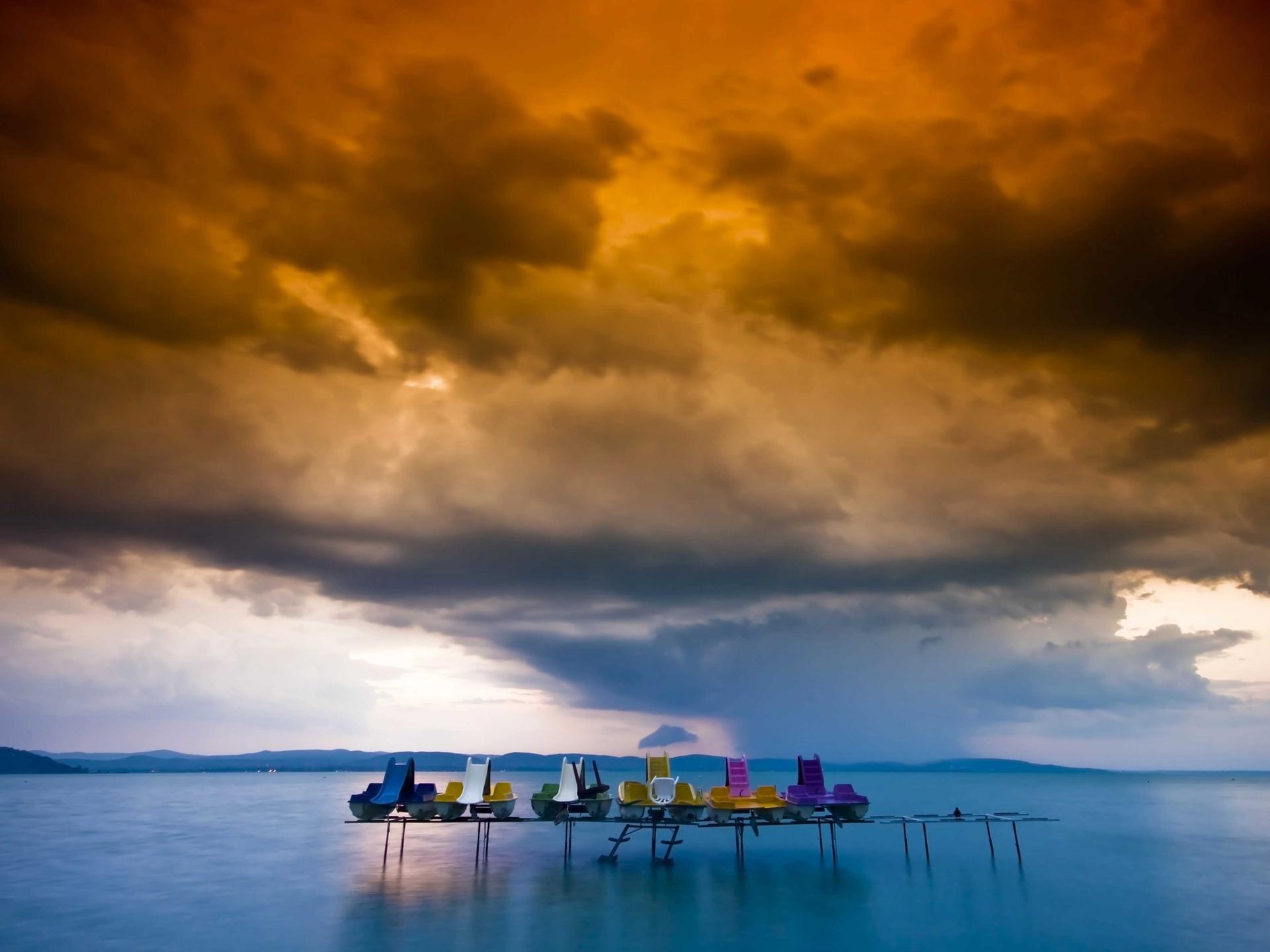 Der Balaton-See bei Sonnenuntergang: Aufgereihte Tretboote nebeneinander auf einem Steg mit Rutschen in vielen Farben.