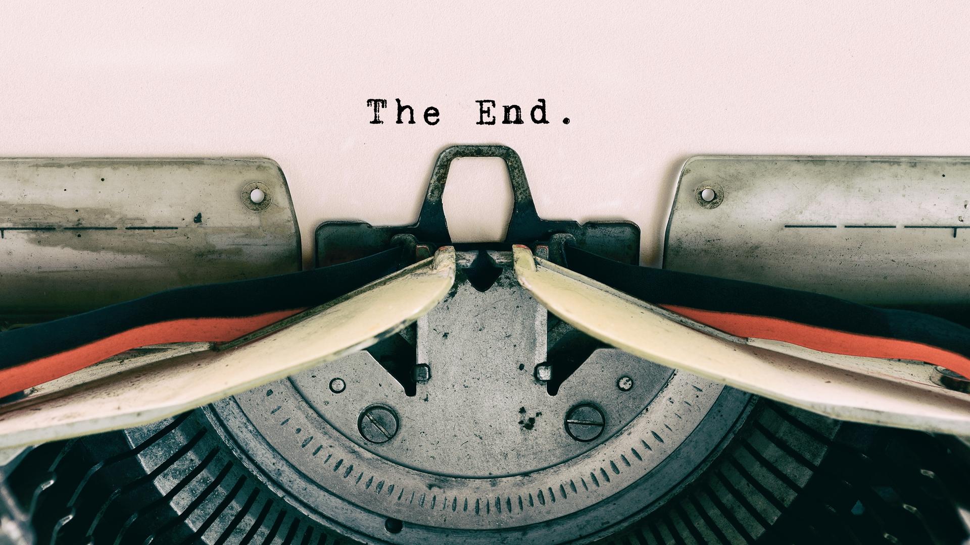 Großaufnahme einer Schreibmaschine, mit der die Worte "The End" auf ein Blatt Papier getippt wurden.