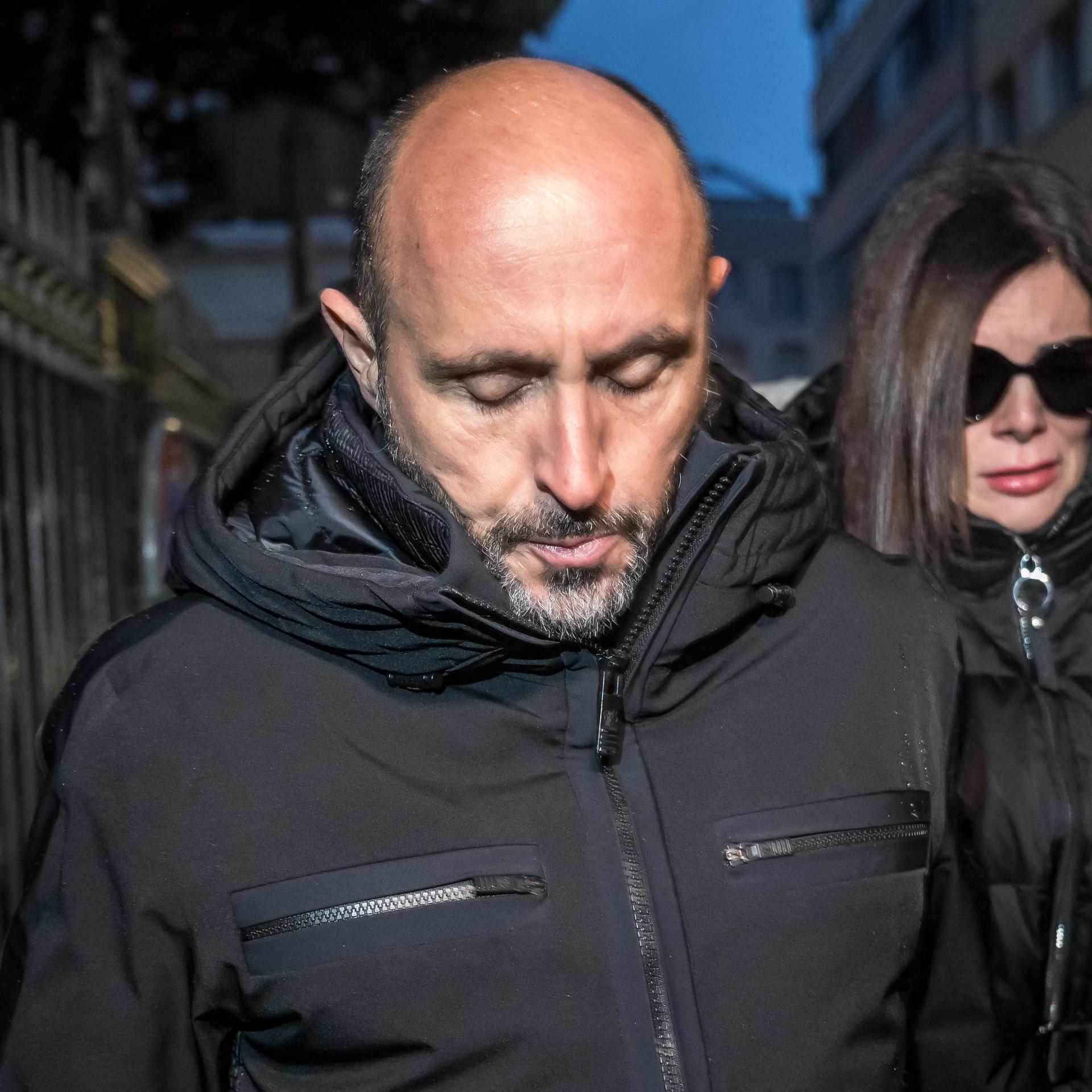 Die französischen Besitzer der Bar in Crans Montana, das Ehepaar Moretti, in Sion. Beide sind schwarz gekleidet. Sie trägt eine große dunkle Sonnenbrille.