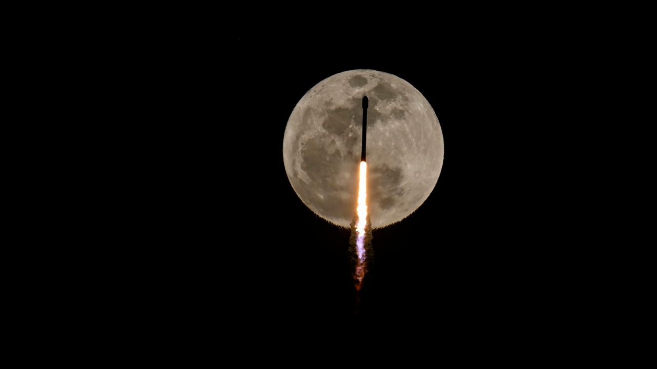 Das Bild zeigt den Mond im schwarzen All. Vor seiner Oberfläche fliegt die Rakete mit einem Feuerschweif senkrecht nach oben. 