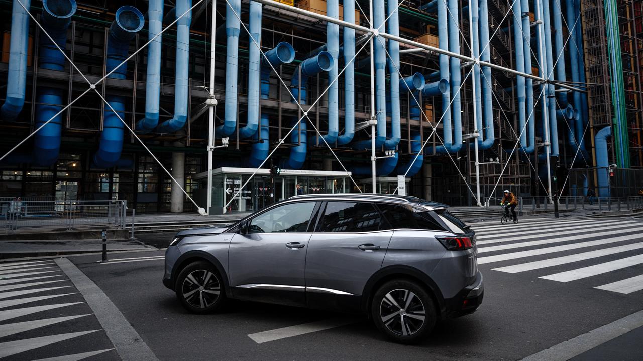 Ein SUV fährt auf der Straße vor dem Centre Pompidou in Paris entlang.