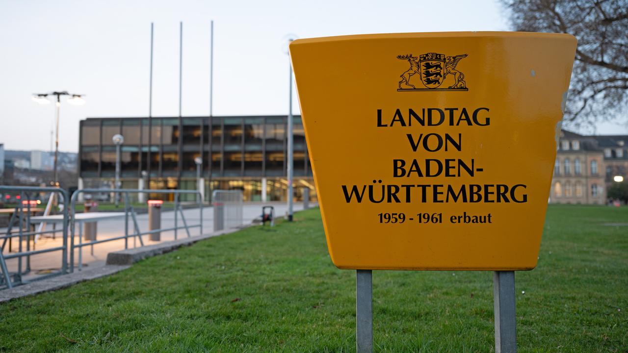 Am Landtag von Baden-Württemberg sind Absperrungen zu sehen, im Vordergrund steht ein großes Schild mit der Aufschrift: "Landtag von Baden-Württemberg 1959-1961 erbaut"